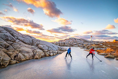 two people playing hockey outside at Peggy's Cove 